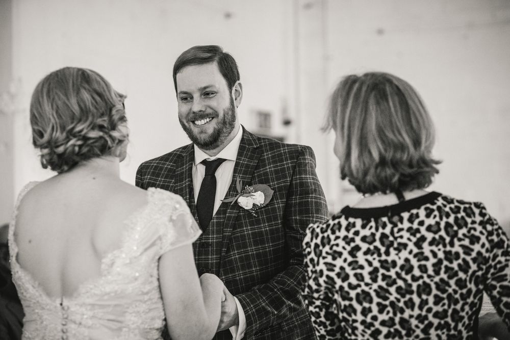 Wedding conversation captured in black and white during reception.