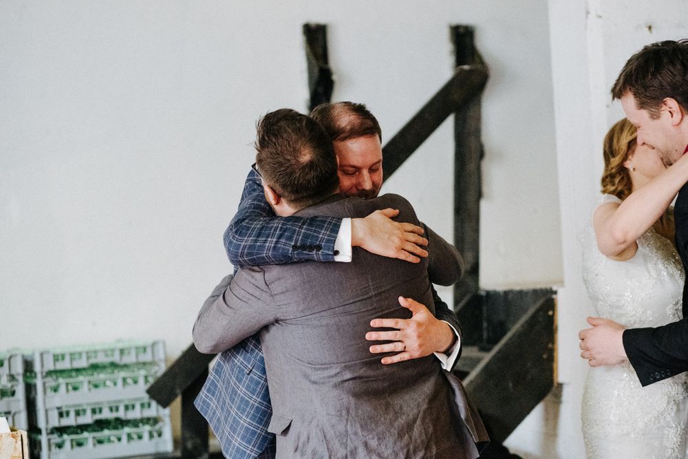 Emotional embrace shared between wedding attendees during celebration.