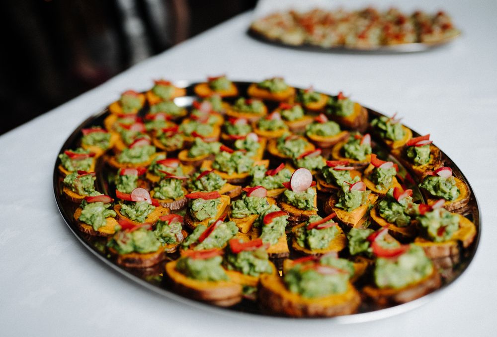 Elegant platter of colorful hors d'oeuvres arranged on white tablecloth.