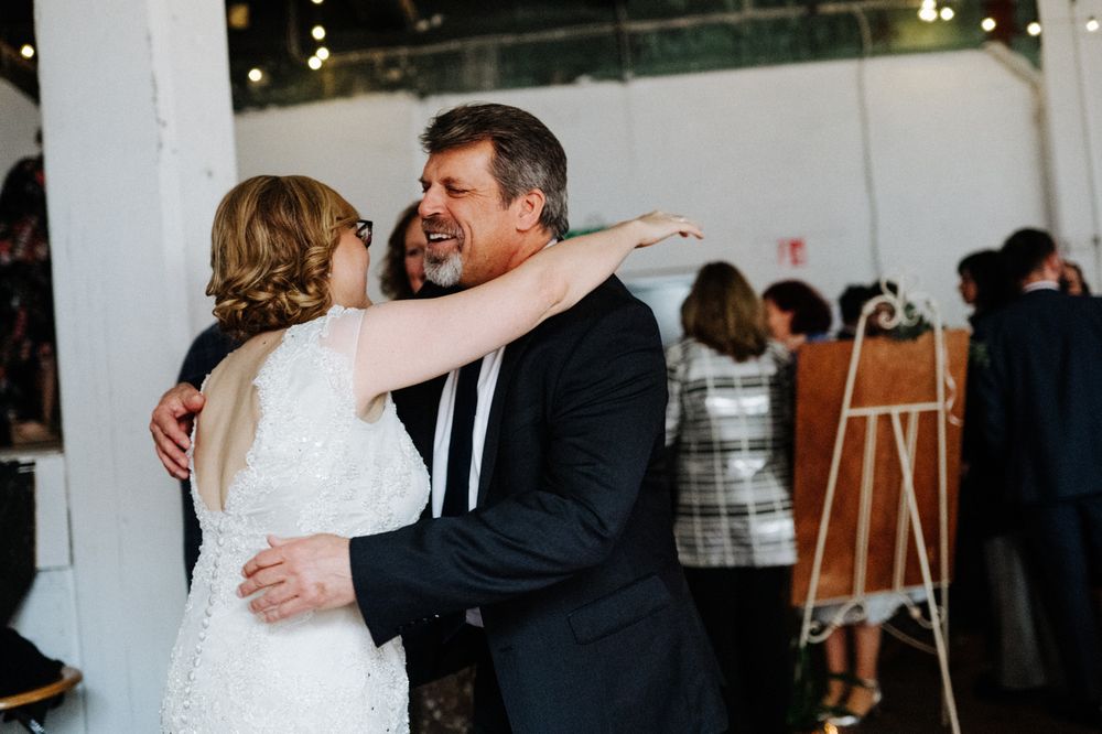 Joyful dance between two wedding guests during celebration in bright indoor venue.