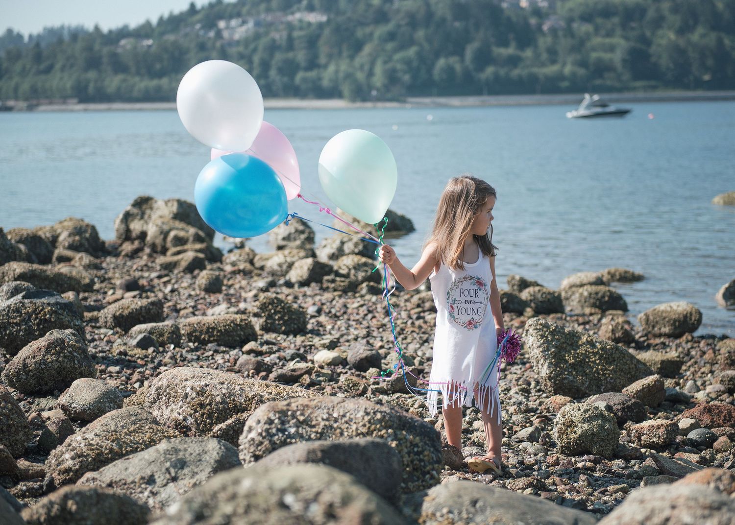 White, blue and pink balloons add festive touch to rocky lakeshore scene.