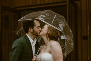 Bride and groom kissing under a clear umbrella at the Juliette chapel wedding venue in Dawsonville, Georgia