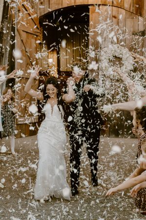Bride and groom making their grand exit with flower petals at the Triple T Farms wedding venue in Fruitdale, Alabama.