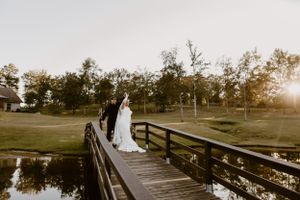 Bride and Grooms slow dancing on a bridge over a lake at Izenstone wedding venue in Spanish Fort, Alabama