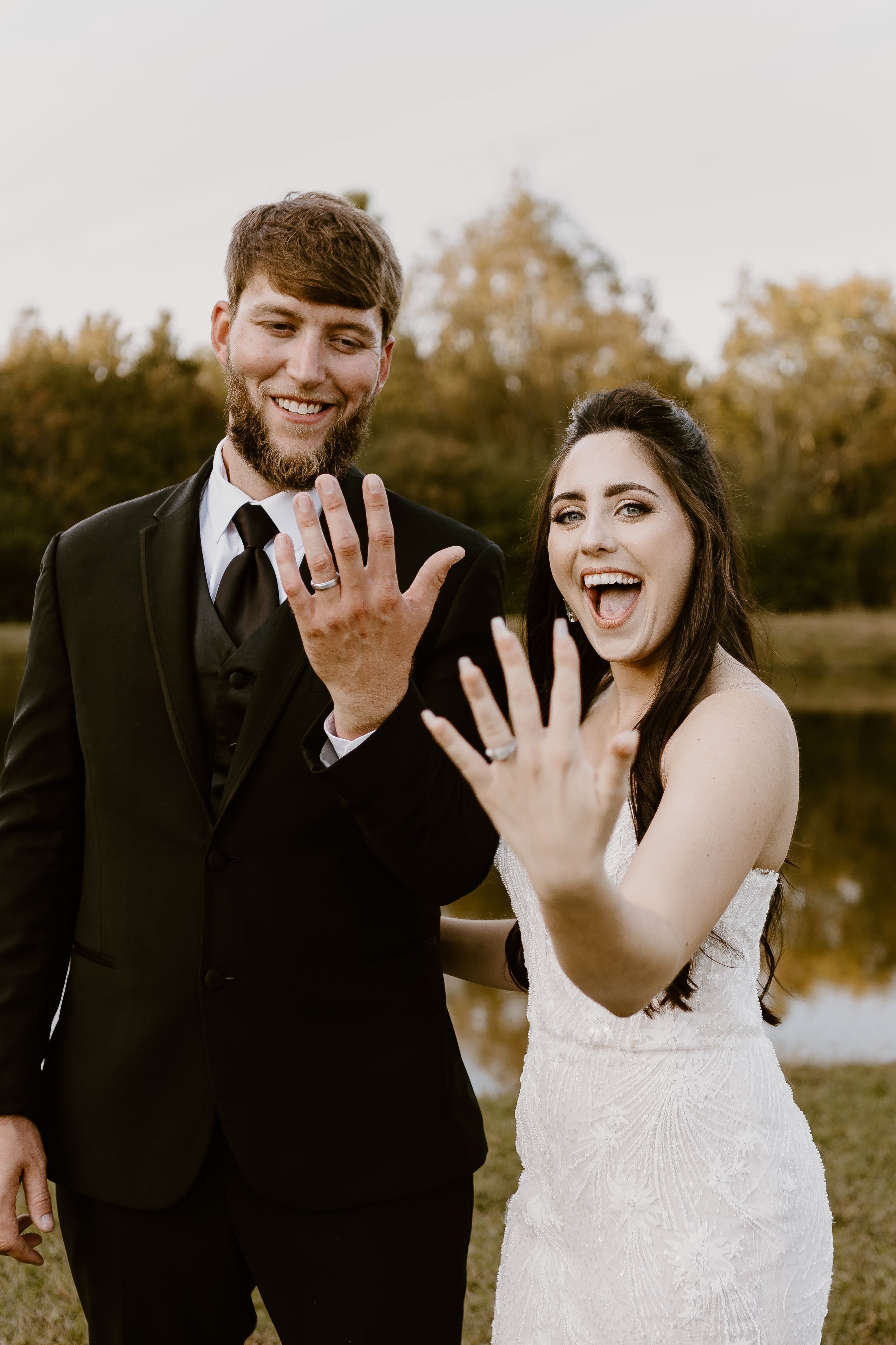 Bride and groom showing wedding rings at triple t farms wedding venue in Fruitdale, Alabam.