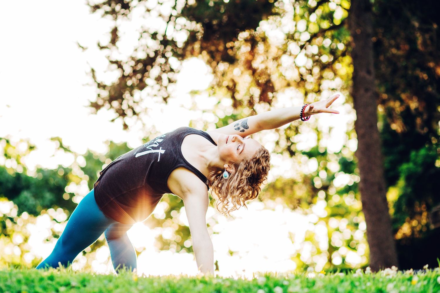 Creative photo of a woman doing yoga outside with sun setting behind her