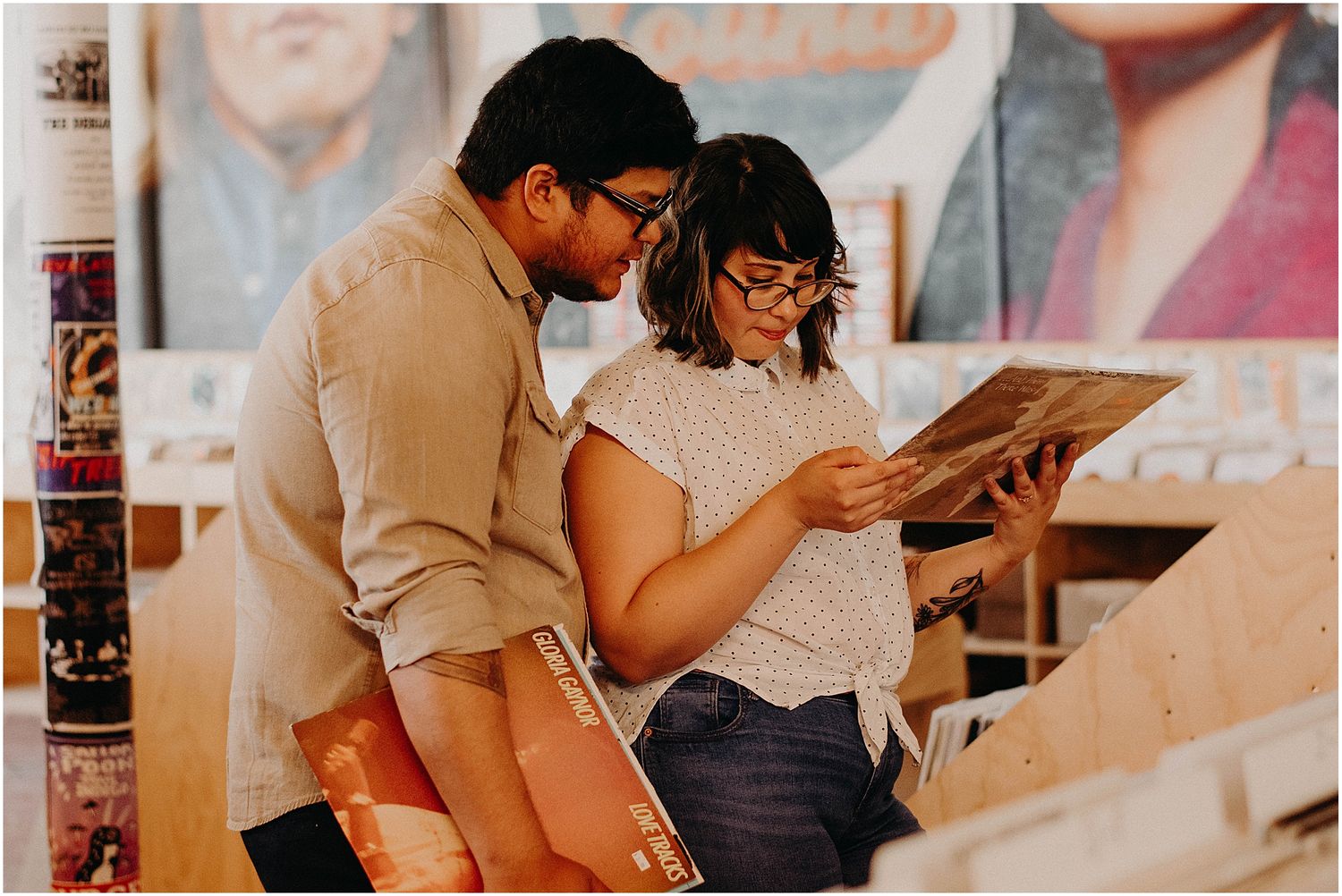 Couple looking through vinyl records together at a record store.
