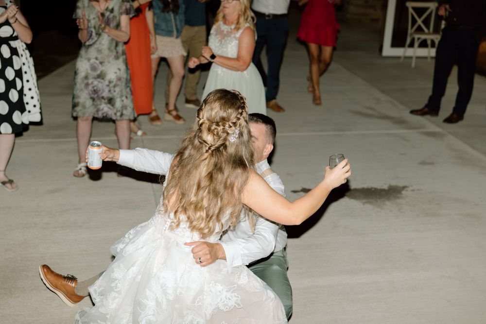Groom sitting on dance floor with bride