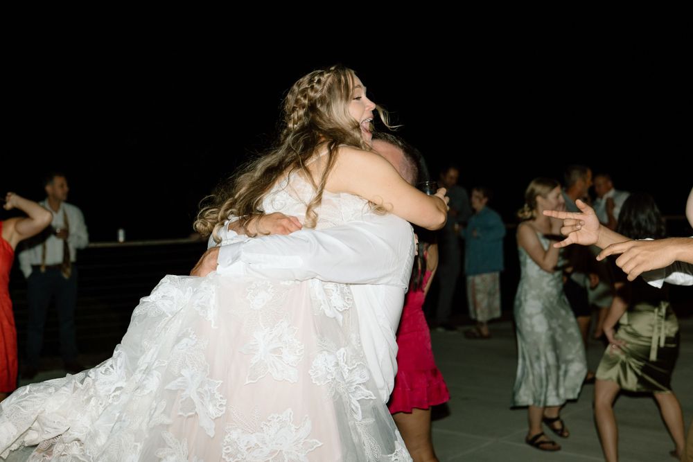 Groom picking up bride on dance floor