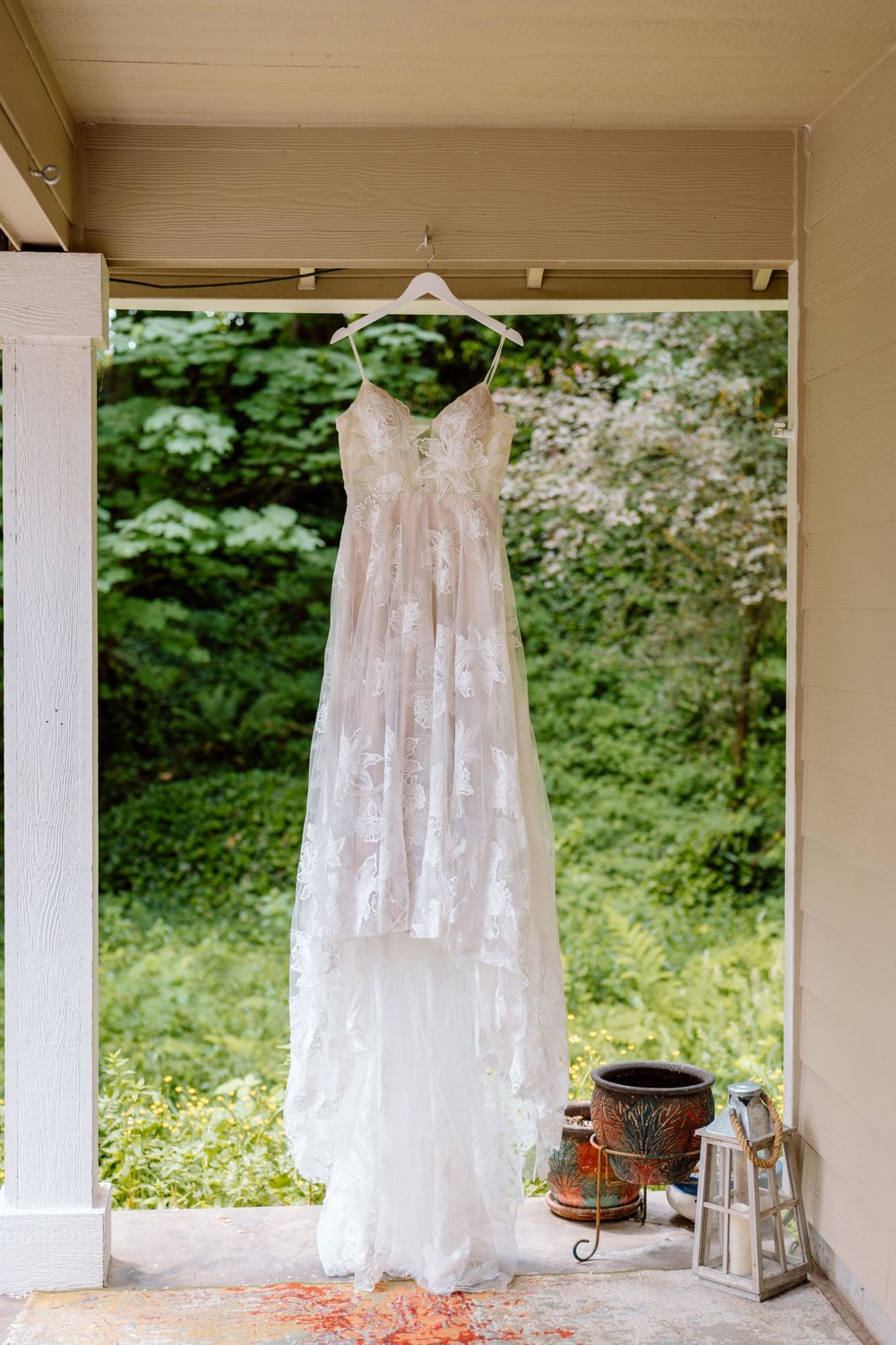 Brides wedding dress hung on porch