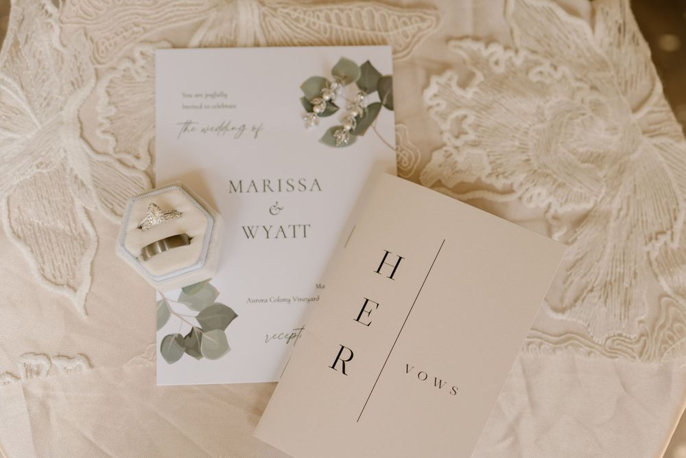 Bride and groom wedding rings with invitations and brides vows