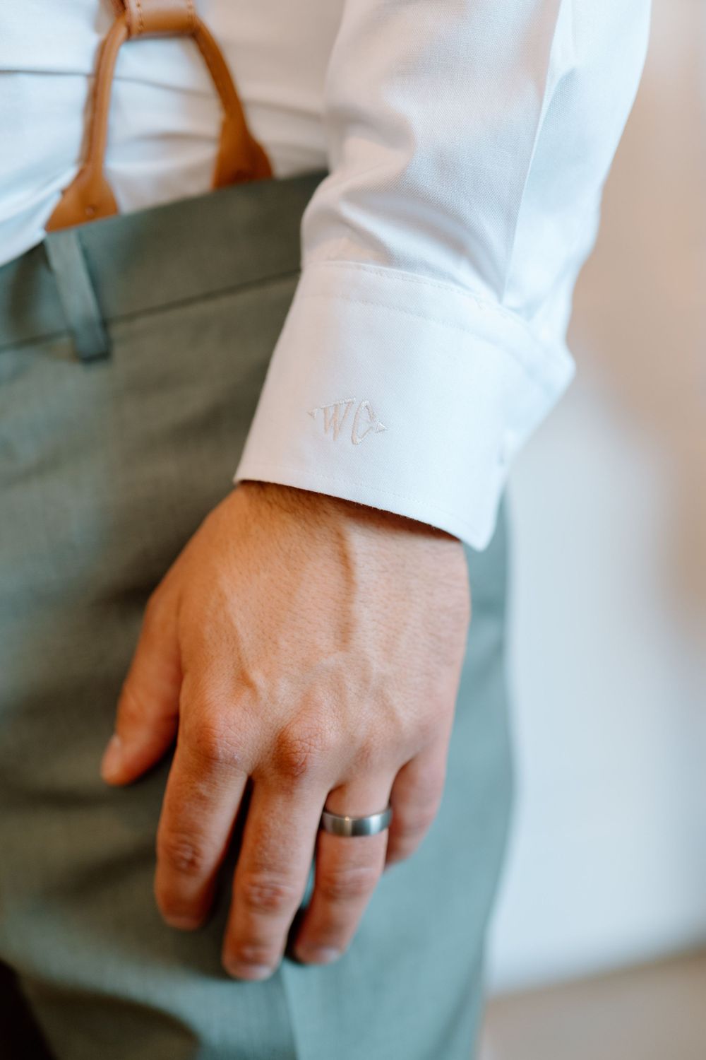 Close up of groom's hand with wedding band