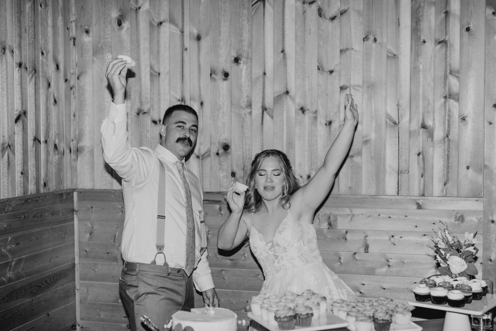 Black and white of Bride and Groom holding cupcake