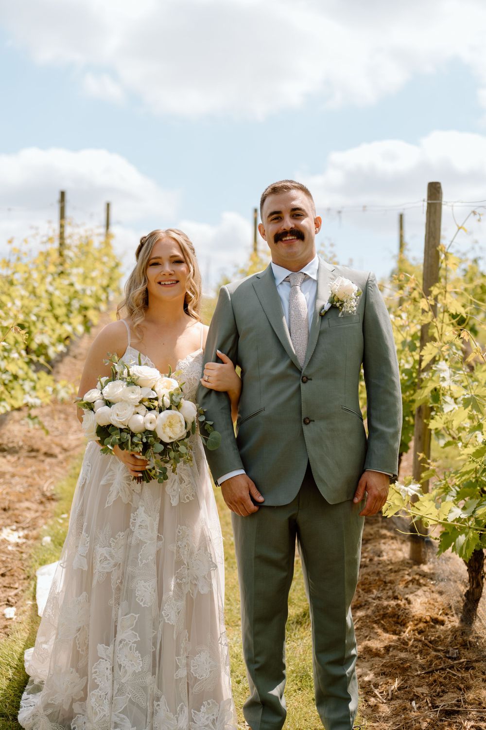 Bride and groom posing in vineyard