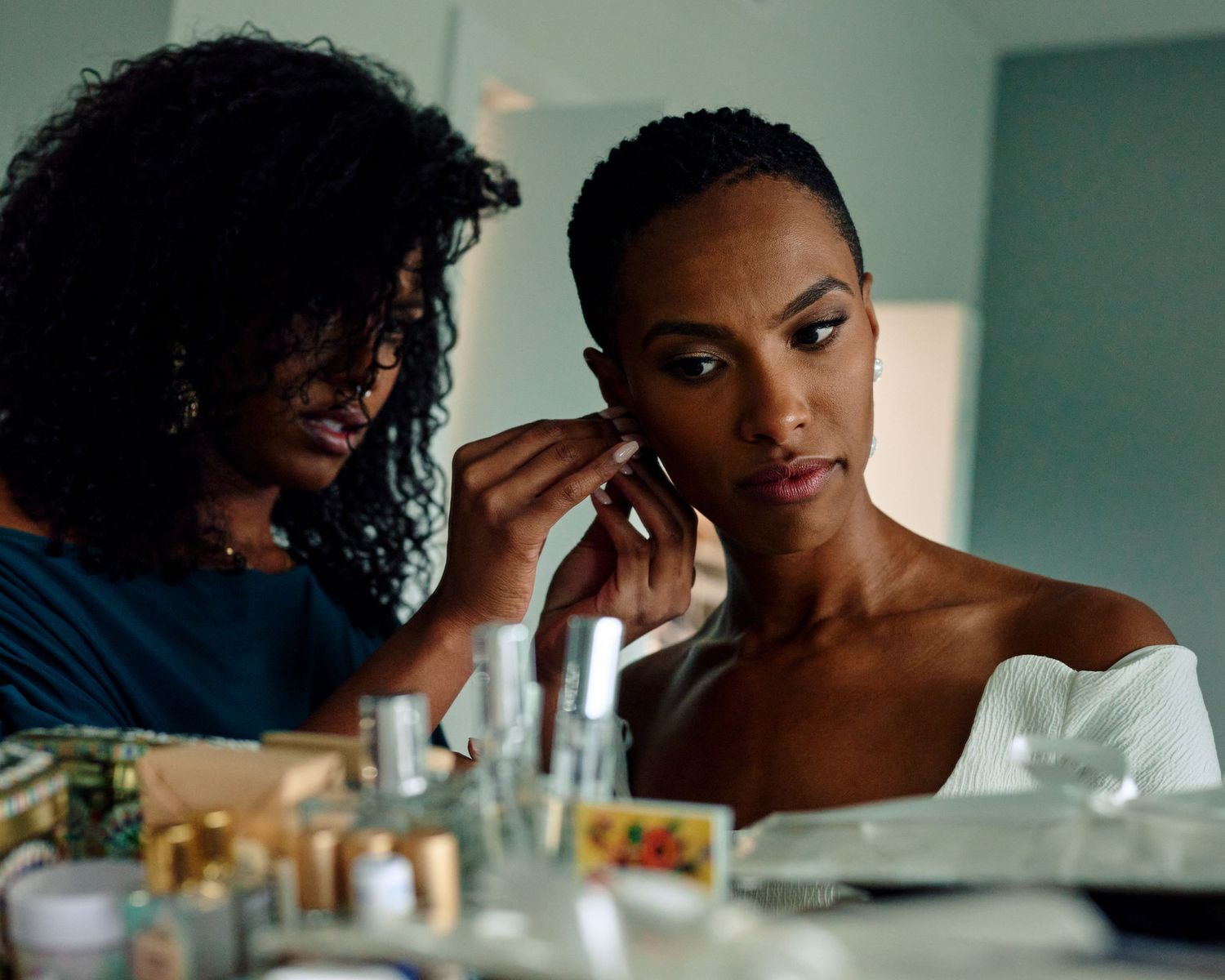 Photograph of bride and sister getting ready for wedding