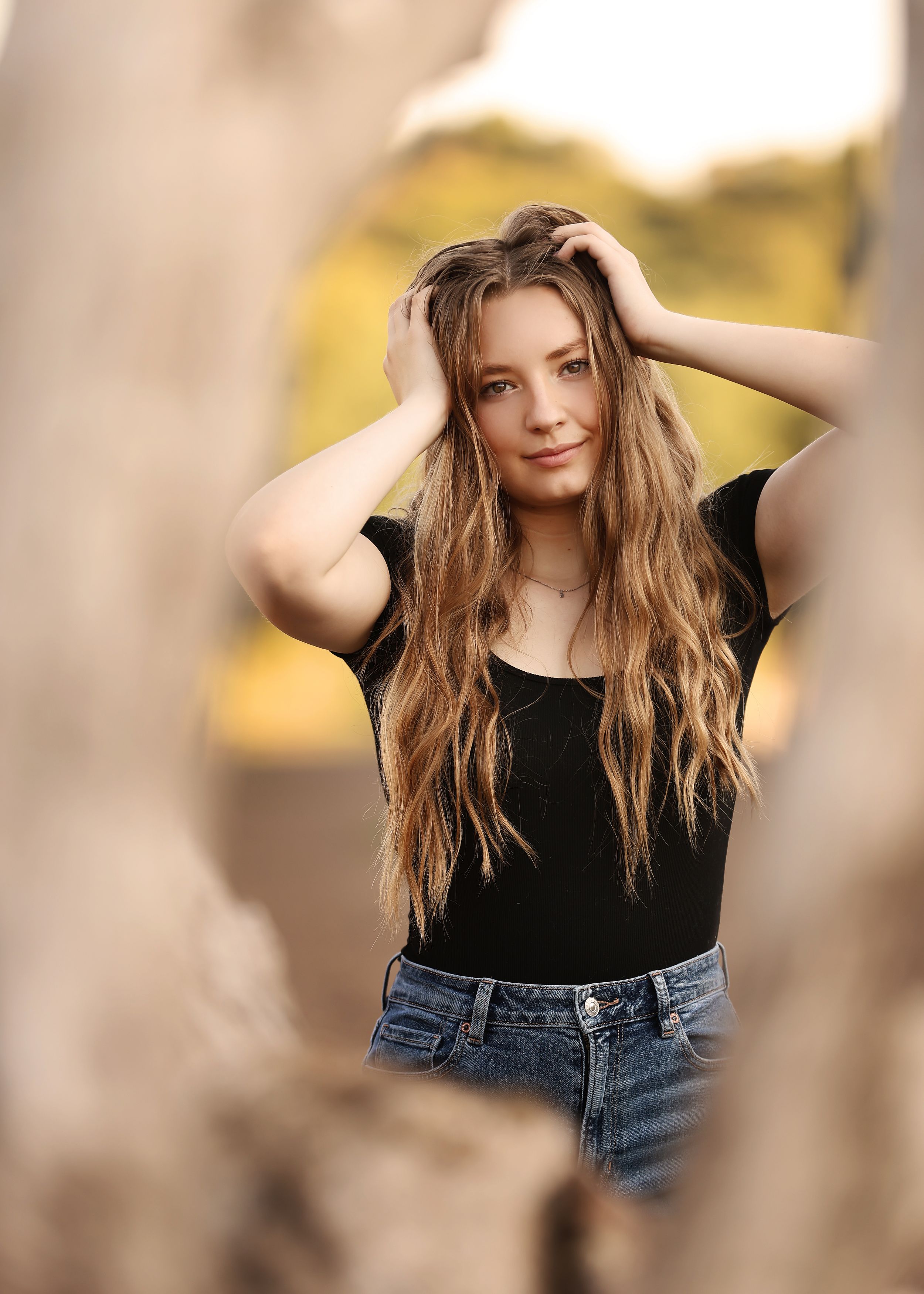 Natural lifestyle portraits with denim and black top in warm lighting.
