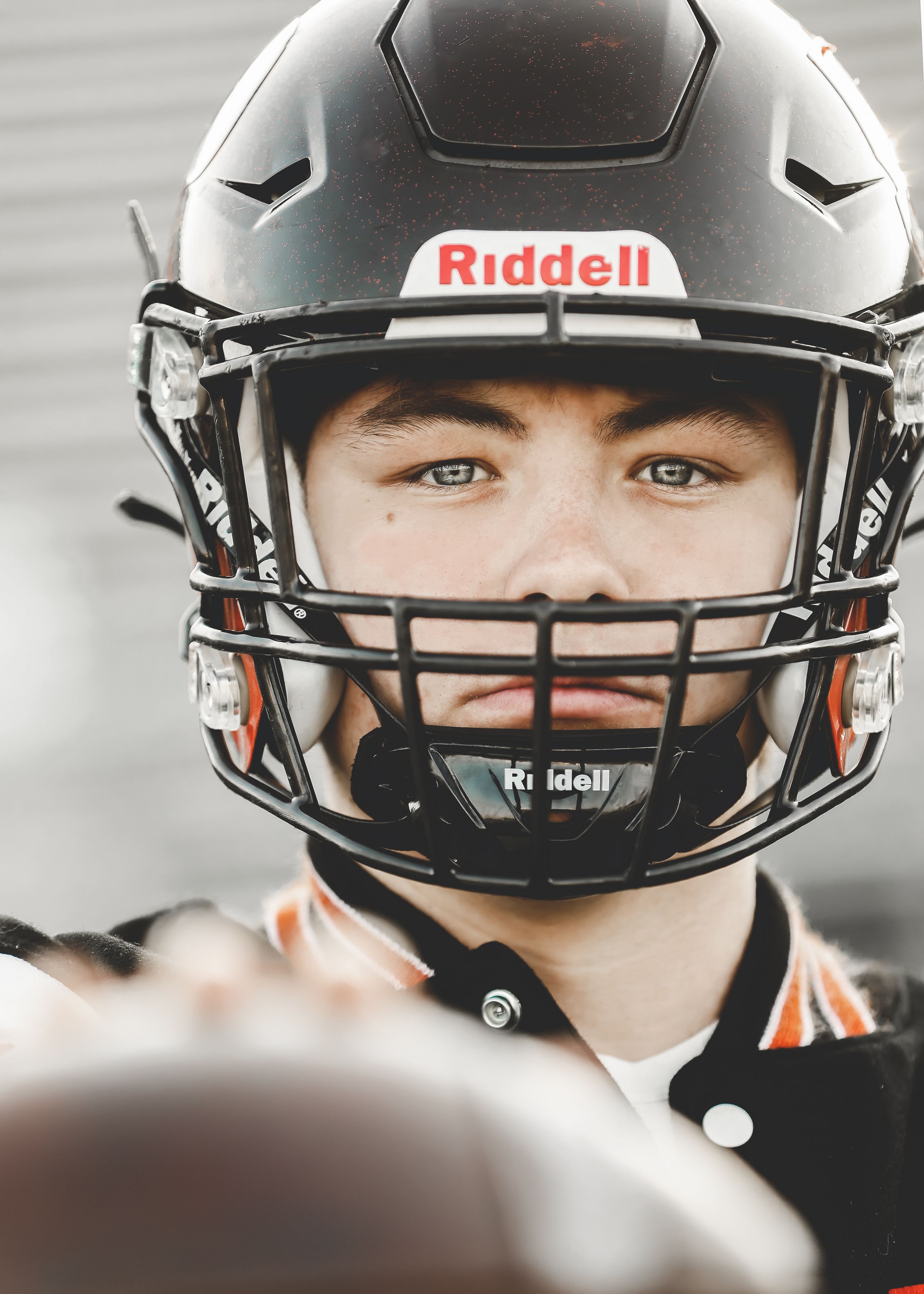 Close-up portrait of athlete in Riddell football helmet.