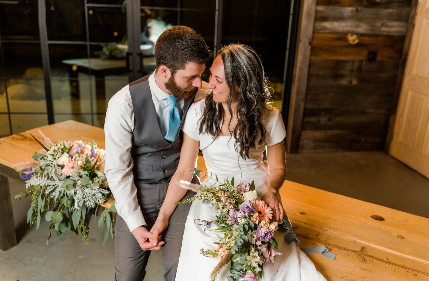 bride and groom sit on the table and hold hands