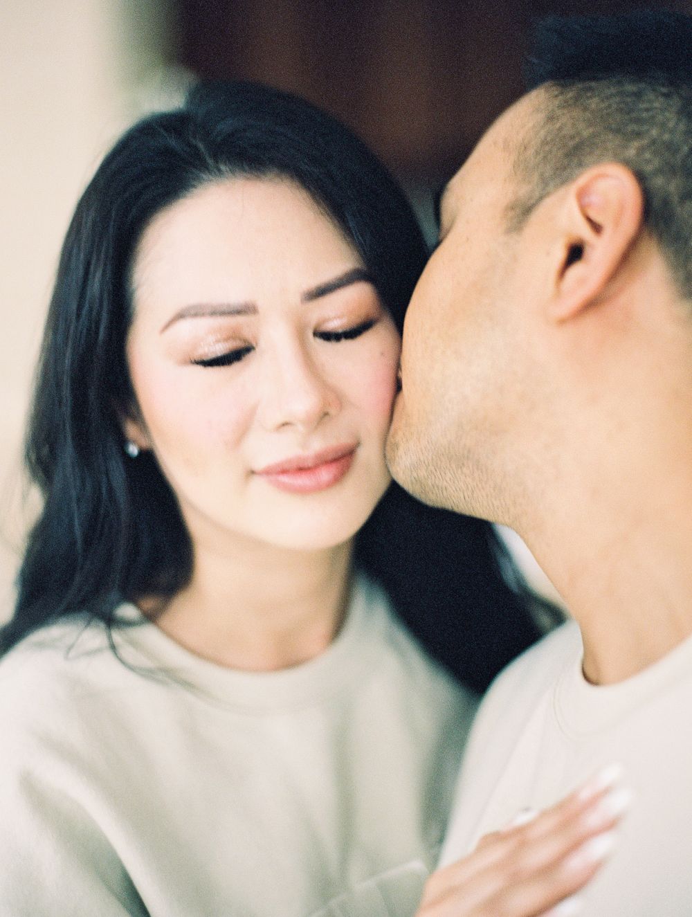 Intimate portrait of couple in cream sweaters with soft natural lighting.