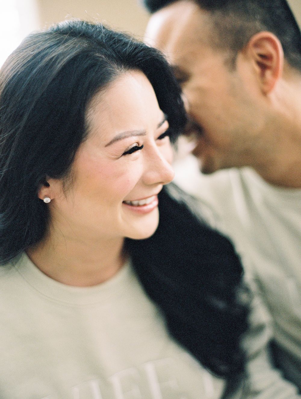 Couple sharing intimate moment and laughter during outdoor photo session.
