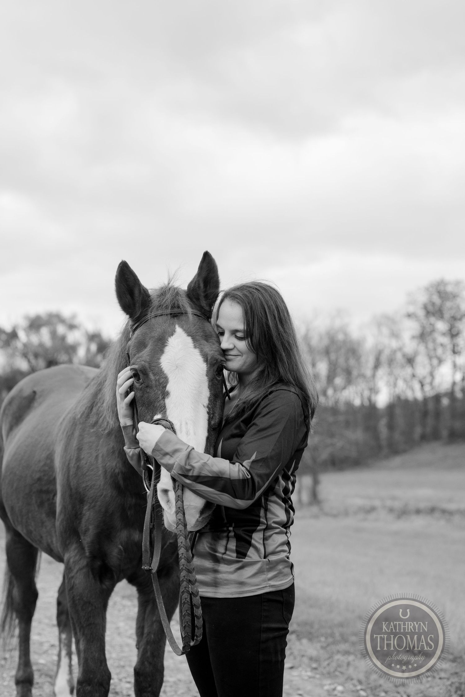 A tender black and white moment shared between a horse with a white blaze and their companion.