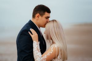 A loving couple sharing a warm embrace on a picturesque beach, creating a beautiful and romantic moment.