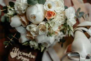 Behold a mesmerizing fusion of a meticulously crafted wedding bouquet, harmoniously accompanied by chic bridal shoes.