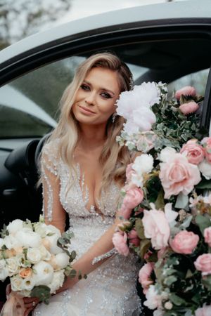 An elegant wedding car embellished with a lovely bridal bouquet, adding a touch of romance to the joyous occasion.