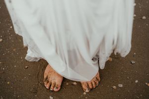 Bare feet covered in sand and dirt, a testament to the woman's adventurous spirit and love for nature's embrace.