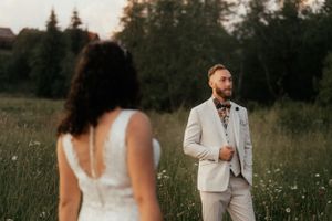 On their special day, a stunning couple stands in a field, wrapped in each other's arms