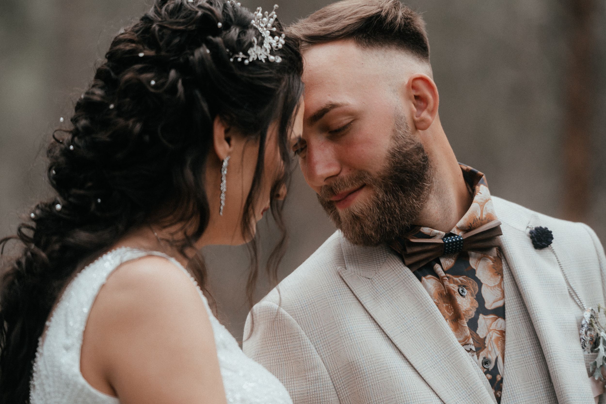 A joyful wedding couple, deeply in love, embracing each other with smiles on their faces.
