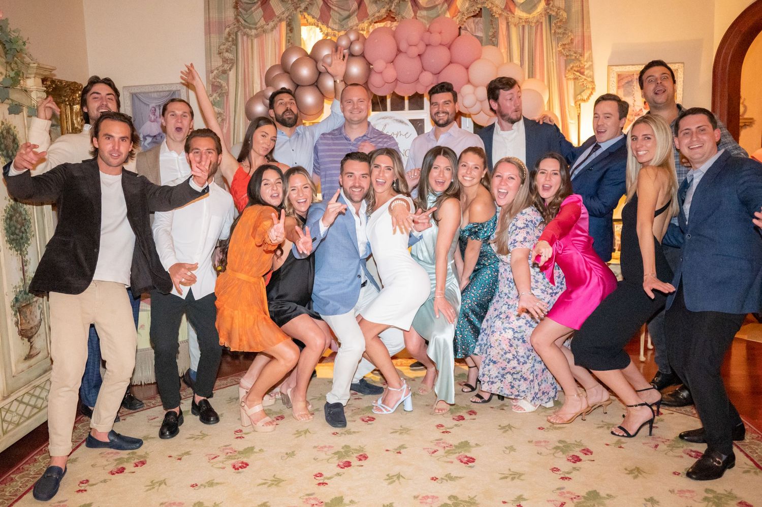 The bride and groom with their friends taking a fun group photo on the night of their rehearsal dinner.