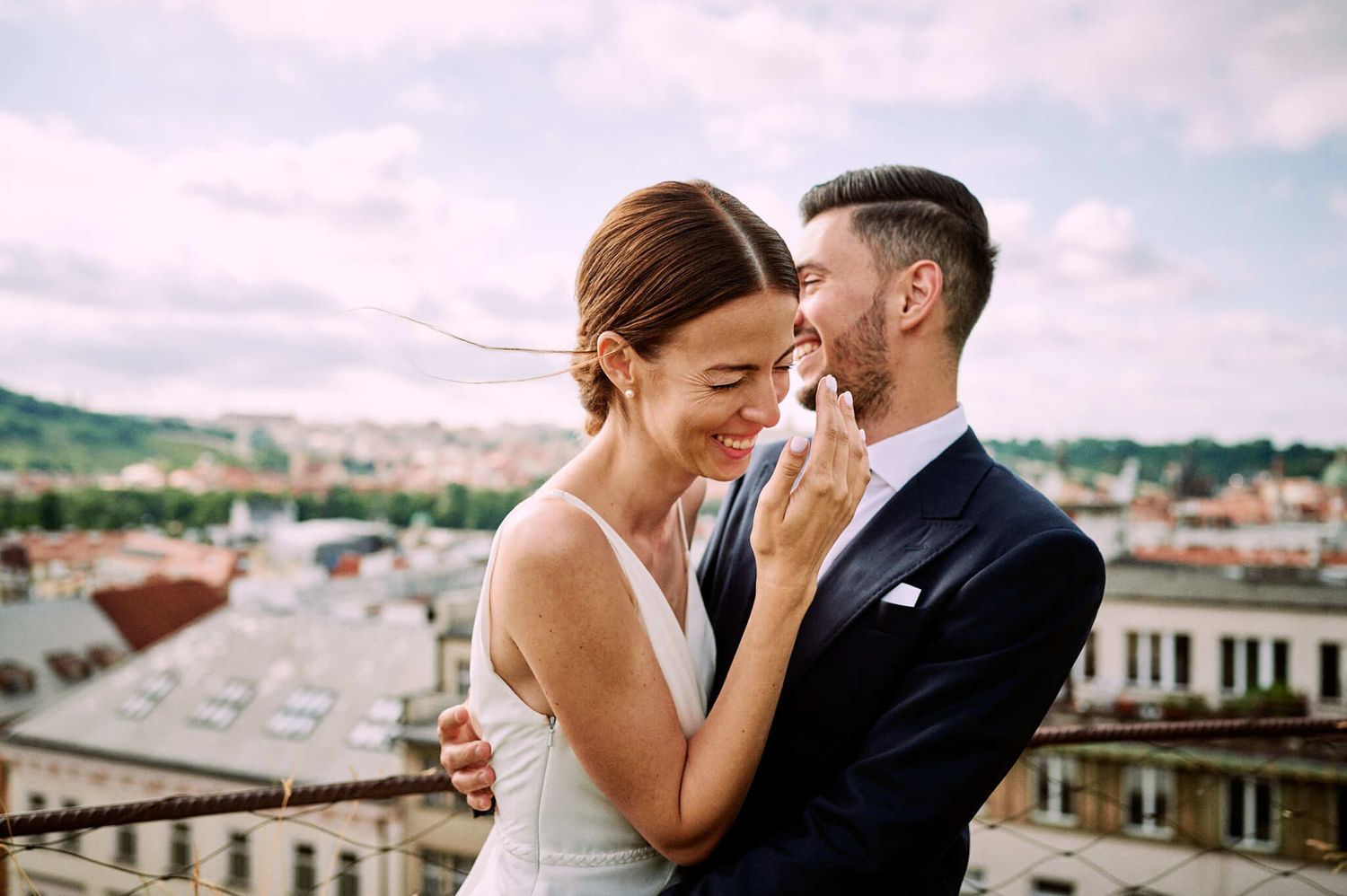 An intimate moment shared between newlyweds against a cityscape backdrop.