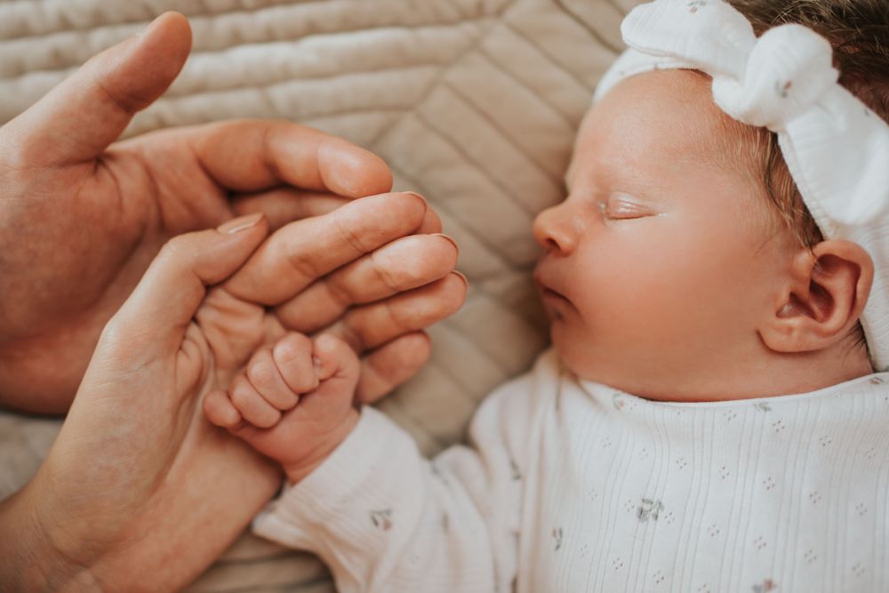 zbliżenie na dłonie noworodka, mamy i taty - sesja rodzinna Kraków