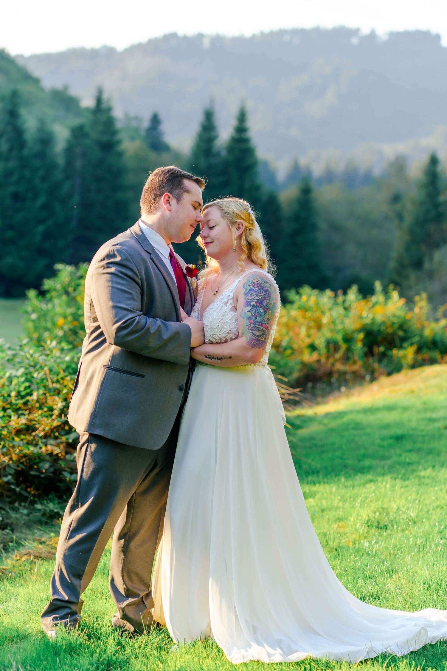 groom and bride embrace with mountain views behind them