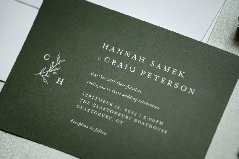 Elegant dark green wedding invitation with white lettering and minimalist design.