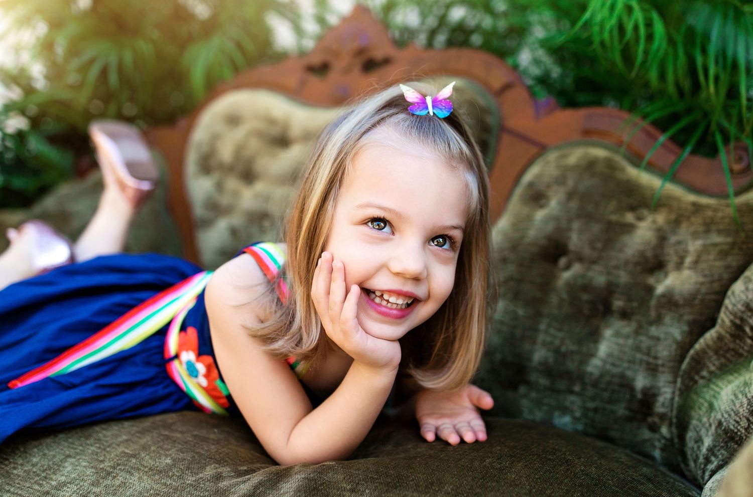 Outdoor portrait session of children playing and posing on decorative stone furniture.