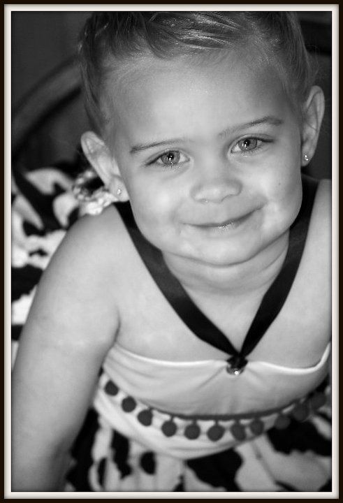 Black and white close-up portrait with pom pom trim detail on dress.