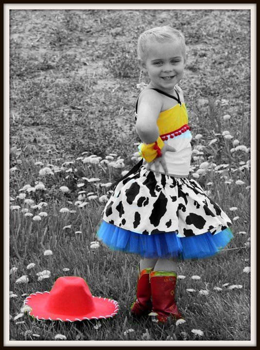 Black and white photo of a dress with cow print and blue tulle against wildflowers.