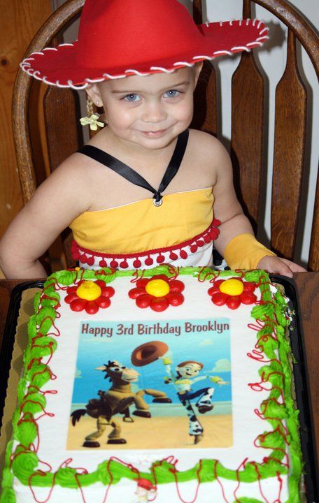 Birthday cake with cartoon characters and decorative red and green frosting borders.
