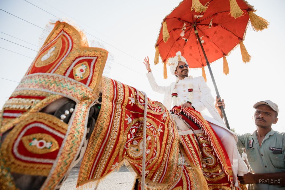 Colorful traditional Indian wedding decorations with ornate patterns and red umbrella.