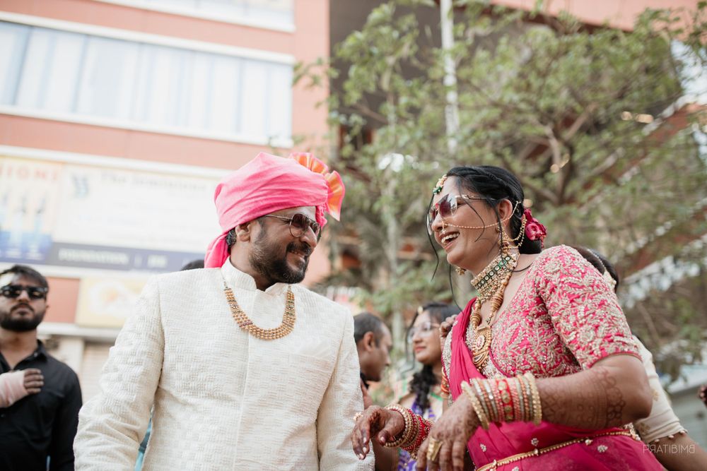 Wedding celebration with traditional Indian attire and bright pink turban outdoors.