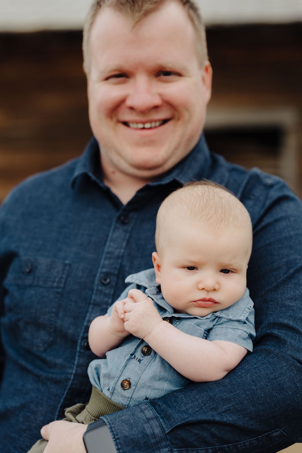 Heartwarming father and baby portrait against rustic wooden background.