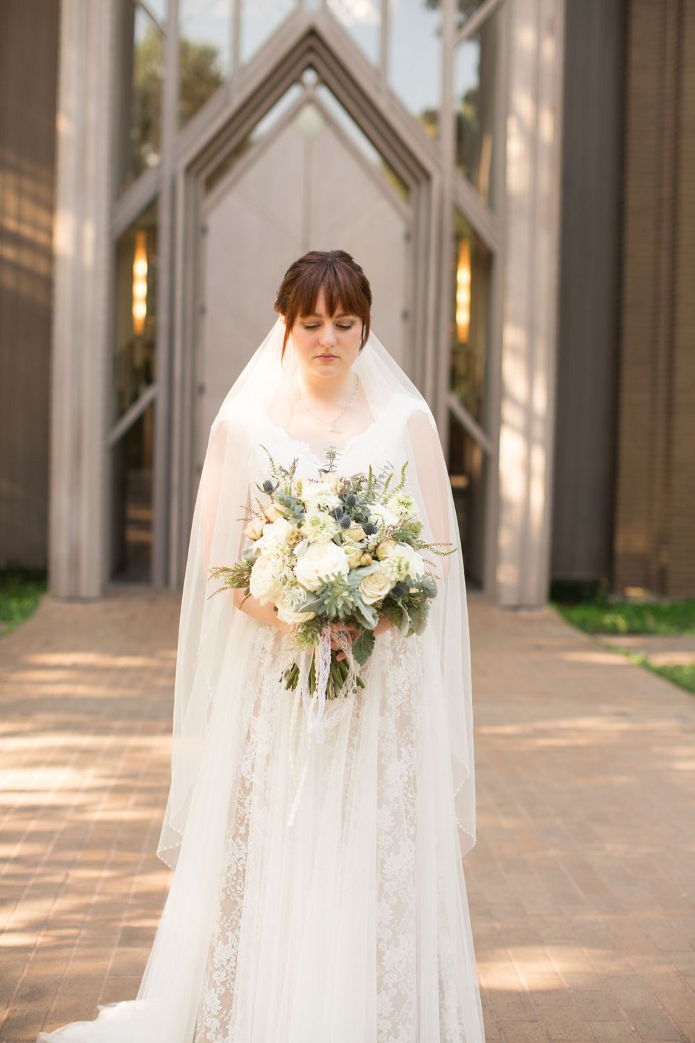 Bridal portraits showcasing a white lace wedding gown and floral bouquet in natural light.
