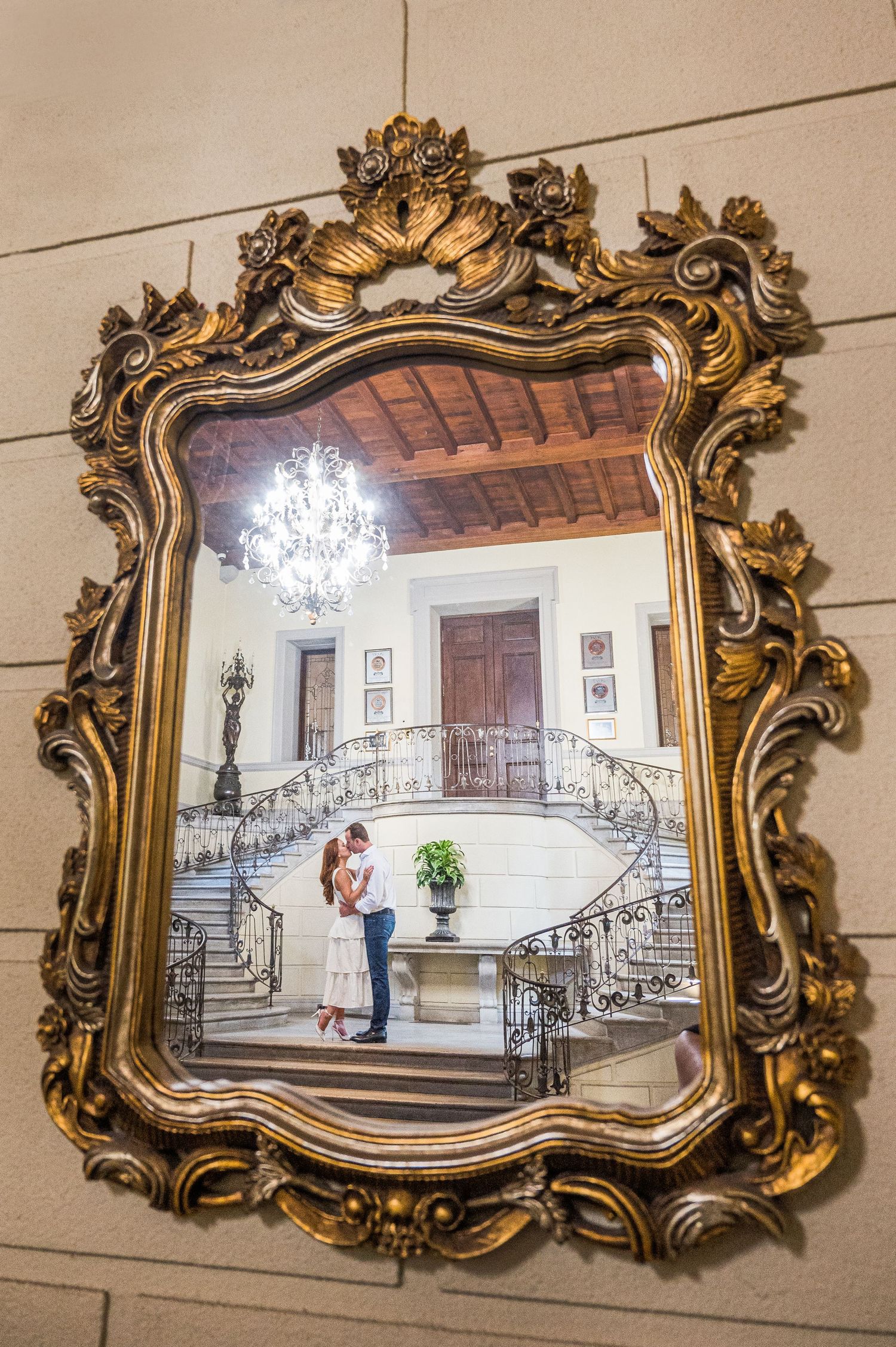 A couple kisses at the majestic entrance of Oheka Castle.