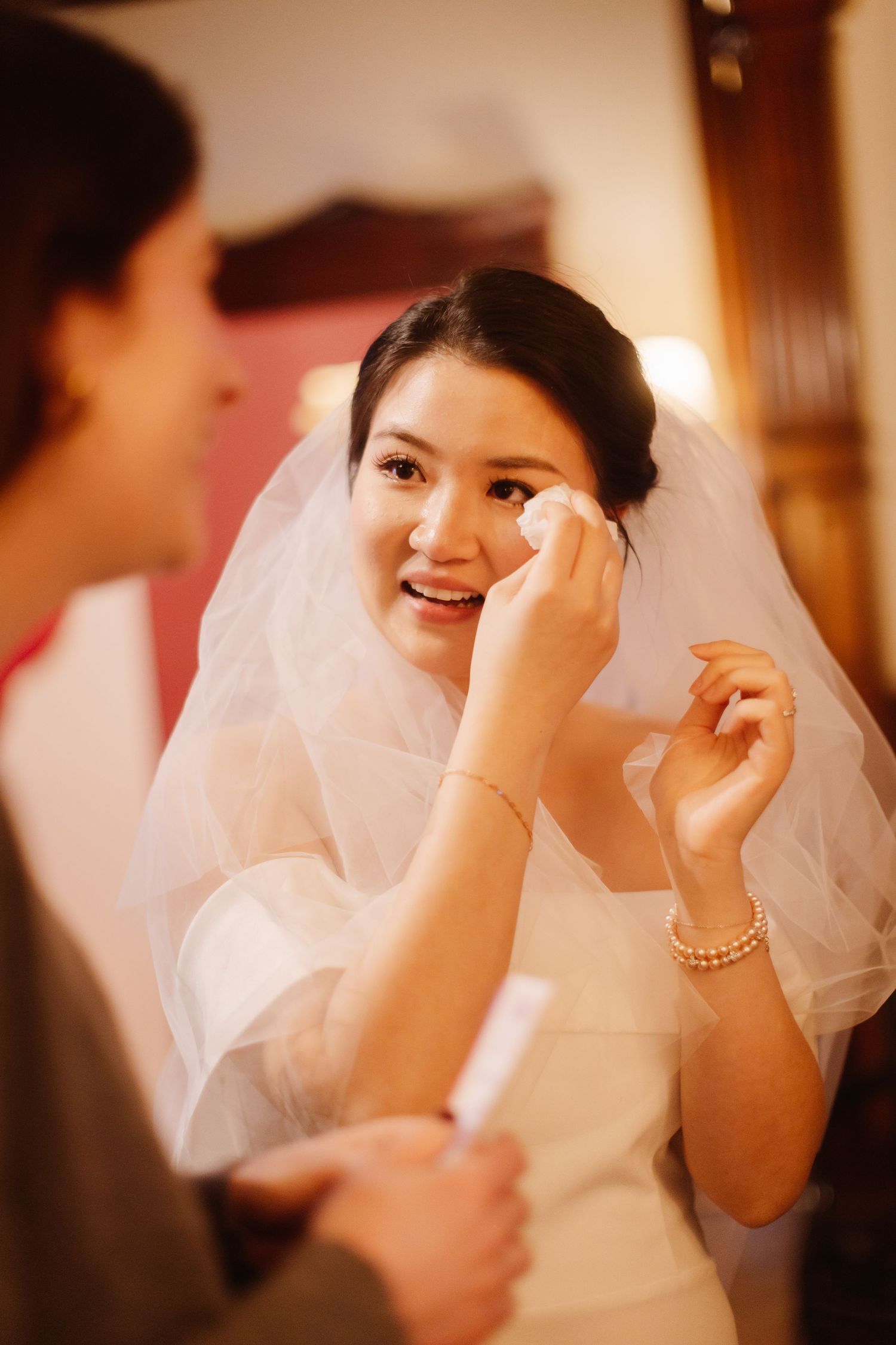 An emotional moment during wedding preparations as tears are wiped away.