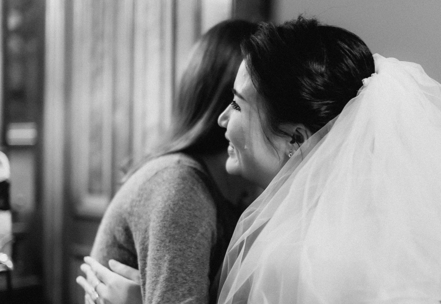 A tender black and white moment captured during wedding preparations.