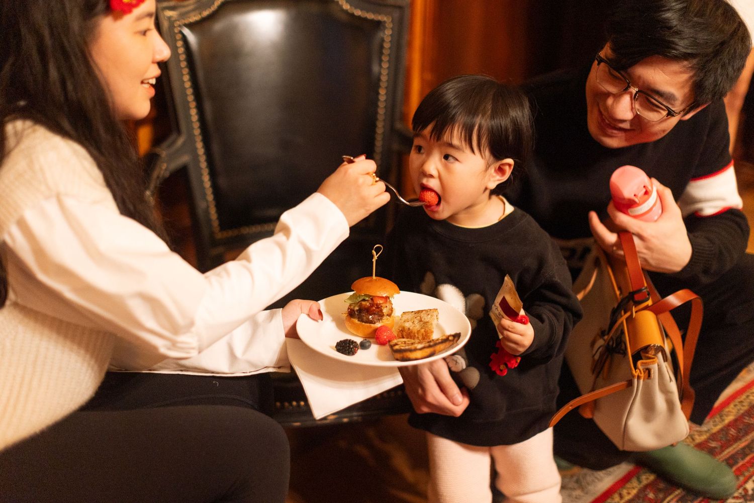 A shared moment during a wedding reception as food is served at a dining table.
