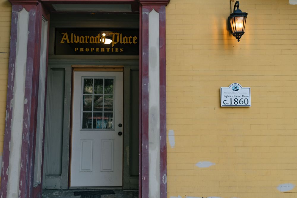 Yellow building entrance with Alliance Place signage and classic lantern fixture.