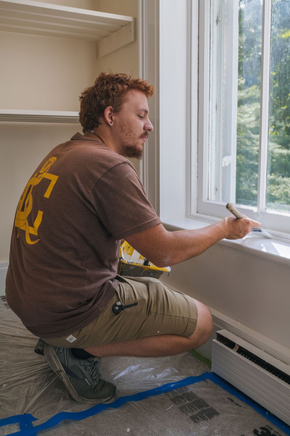 Professional installer working on interior window trim installation.